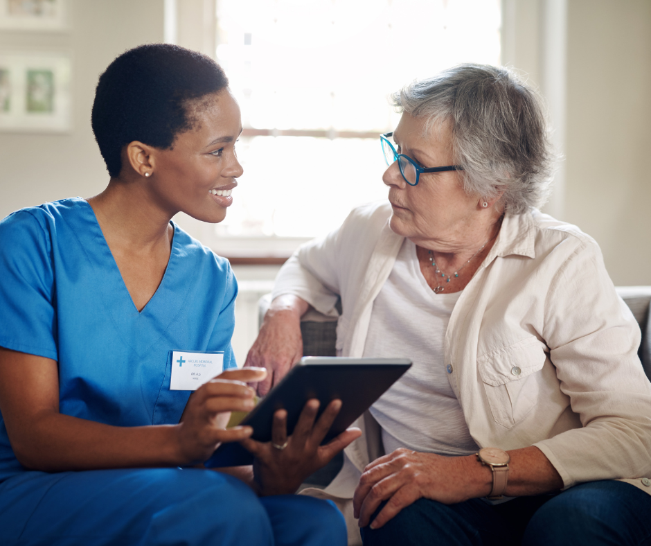 Elder Care Finders advisor in blue scrubs showing senior living options on a tablet to an elderly woman in West Palm Beach.
